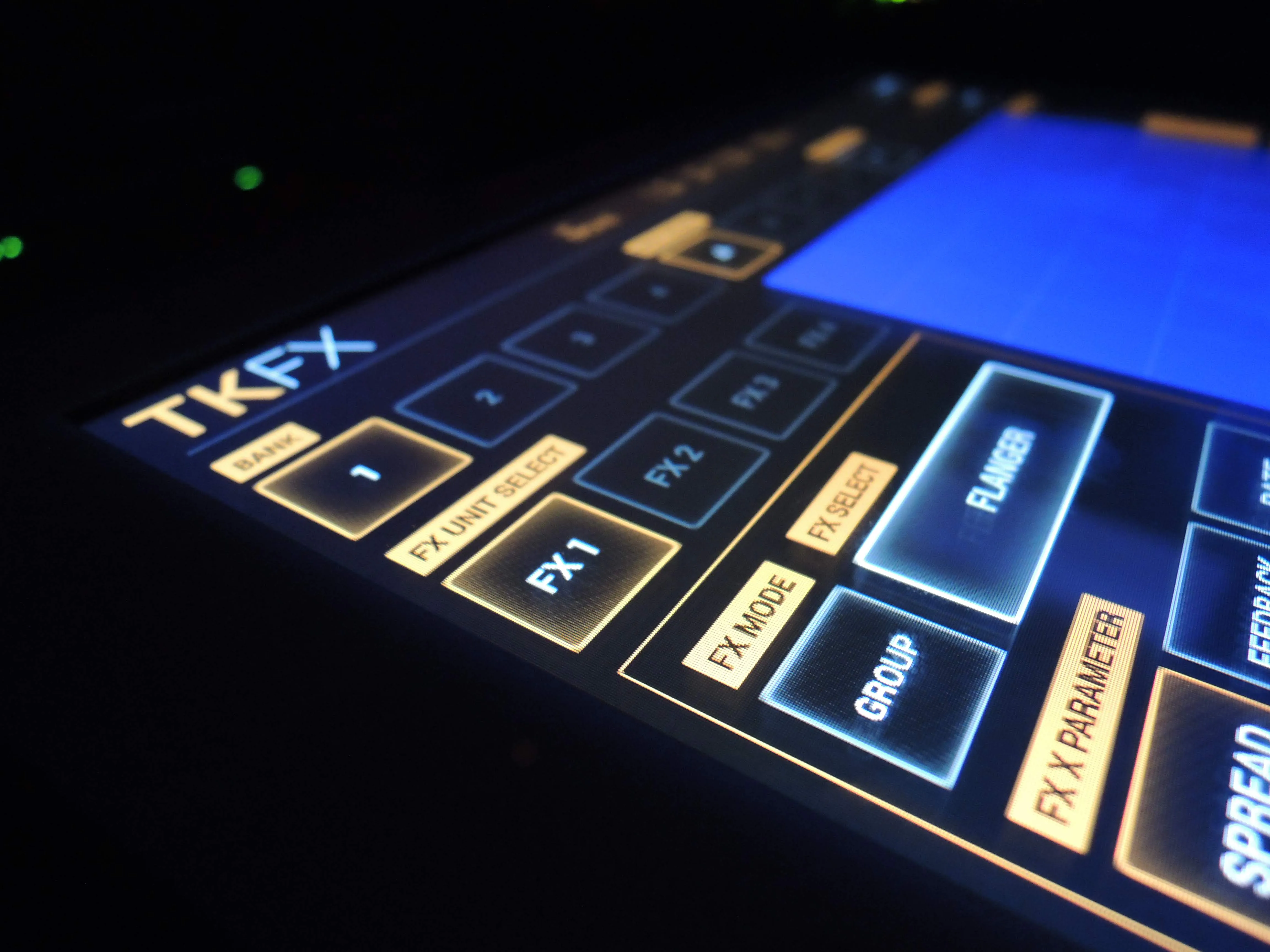 iPhone 上で動く TKFX インターフェースのクローズアップ。オレンジに光る FX ユニット、 明るいシアンに灯る FLANGER 選択パッドの隣に並ぶバンクとモードのボタン、 暗い面の上で低い角度から撮影。