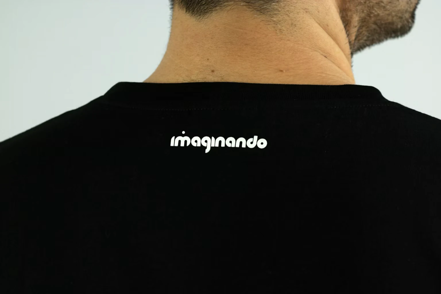 肩の間の控えめな白い Imaginando ワードマーク