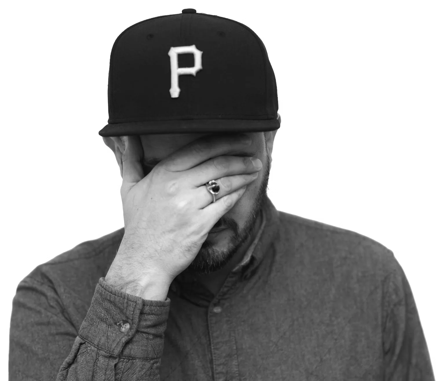 Pat Pardy of Evil Nine, in a black cap, resting his face in one hand.