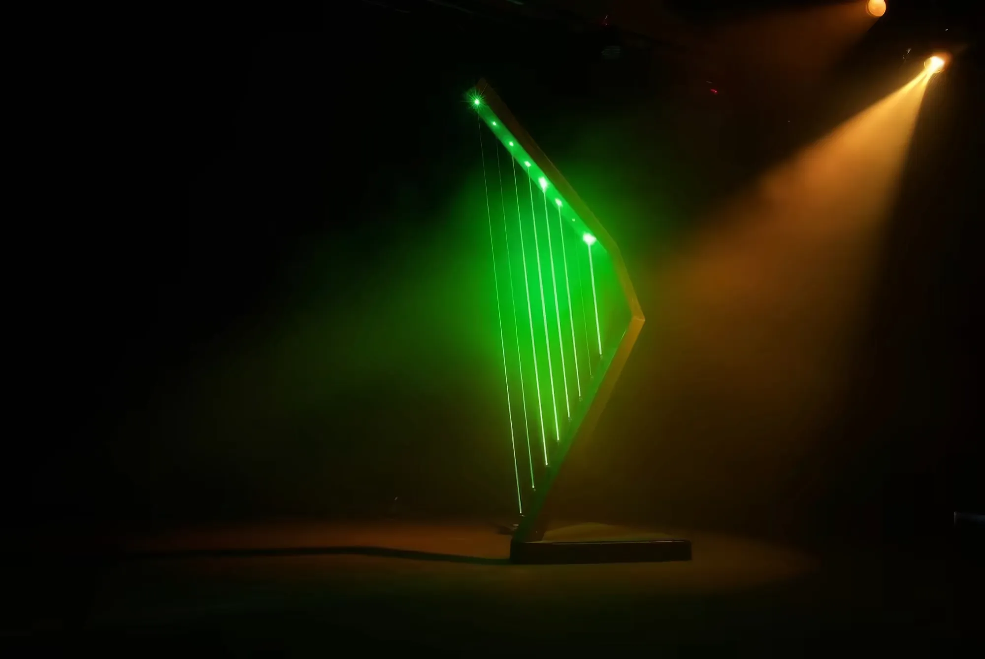 煙に満たされたステージにぽつんと立つ Harpa Laser。6本の緑色のレーザー光線が 深い闇を背に縦に輝いている。